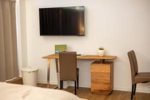 a room with a desk and a television on the wall at Uelser Hof in Uelsen