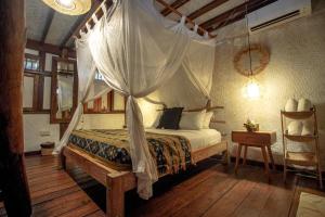 a bedroom with a bed with a mosquito net at The Calmtree Bungalows in Canggu +125 photos