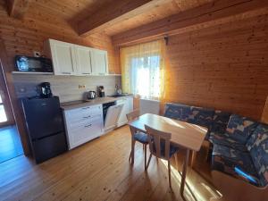 a kitchen with a table and a dining room at Roubenka pod Čerťákem in Dolní Moravice