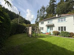 a house with a playground in a yard at The lodge in Bodmin