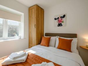 a bedroom with a bed with a cow picture on the wall at 2 Bed in Louth oc-53508 in Fotherby