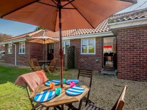 a wooden table with an umbrella in a backyard at 2 Bed in Louth oc-53508 in Fotherby