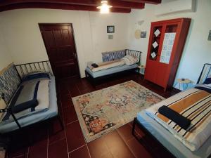 a room with three beds and a red door at Kiscsengőd Vendégház in Csengőd