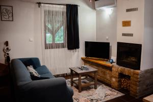 a living room with a couch and a tv and a fireplace at Kiscsengőd Vendégház in Csengőd