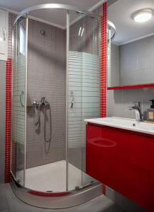 a bathroom with a shower and a sink and red cabinets at Olive Nest, Cozy Apartment in Ammoudara in Ayía Marína