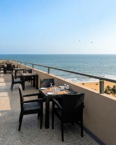 a row of tables and chairs on a balcony overlooking the beach at Sea view Serenity Negombo in Negombo
