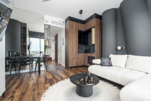 a living room with a white couch and a table at Hanza Signature Sky in Szczecin