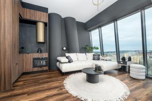 a living room with a couch and a table at Hanza Signature Sky in Szczecin +7 photos