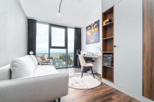 a living room with a white couch and a desk at Hanza Signature Sky in Szczecin