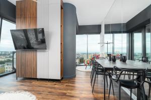 a dining room with a table and chairs and windows at Hanza Signature Sky in Szczecin