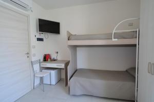 a small bedroom with a bunk bed and a desk at Camere da Angelo in Tortolì +28 photos
