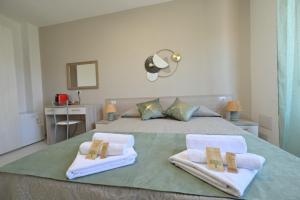 a bedroom with a bed with towels on it at Camere da Angelo in Tortolì