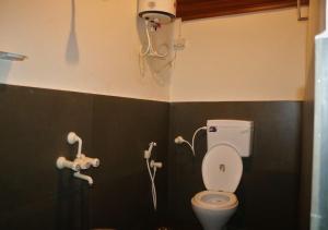 a bathroom with a toilet and a shower at The Wildcamp - Coorg in Kushālnagar