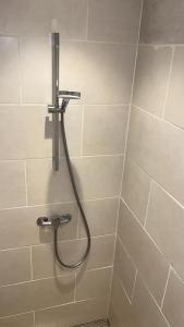a shower with a hose in a bathroom at La Boulangerette - Studio in Kralingen in Rotterdam +57 photos