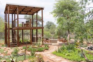 a garden with a wooden pavilion with tables and chairs at Afrikaya Villas in Hoedspruit +8 photos
