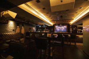 a bar with chairs and a television in a room at Esthell Hotel in Chennai