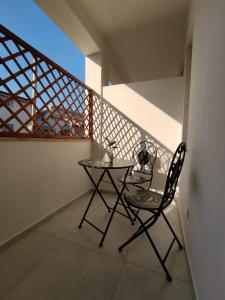 a small table and a chair on a balcony at Camere da Angelo in Tortolì