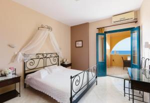 a bedroom with a bed and a view of the ocean at Archipelagos Apartments in Arkasa
