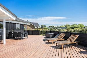 a deck with chairs and a grill on a house at OH287-Hadsund-Haslevgarde-Eng-1 in Hadsund