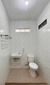 a white bathroom with a toilet and a sink at Omah Ndoro Sugih in Serut +21 photos