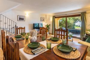 a dining room with a wooden table with green plates at Cagliari Bay View Villa in Quartu Sant'Elena