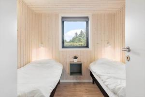 two beds in a room with a window at OH419-Hadsund-Halvrebene-60 in Hadsund