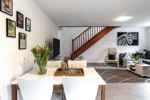 a living room with a table and white chairs at Hamburg - Haus - Airport 2 in Hamburg