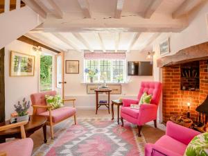 a living room with pink chairs and a fireplace at 2 Bed in Salisbury oc-88922 in Boreham