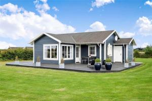 a blue house with a deck in a yard at OH359-Storvorde-Kongeornen-62 in Storvorde
