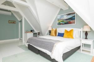 a bedroom with a white bed with yellow pillows at The Willets Boutique Hotel in Simonʼs Town +240 photos
