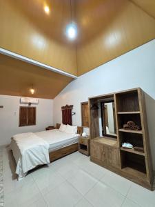 a bedroom with a large bed and a mirror at Omah Ndoro Sugih in Serut