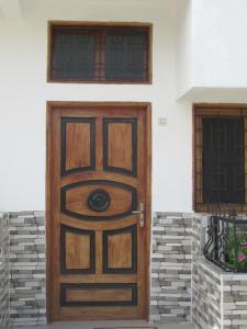 a wooden door on a house with a window at Résidence Séjour Téranga in Saint-Louis +4 photos