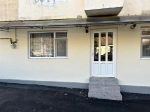 a white house with a white door and windows at Central Apartment in Zalău