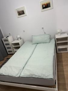 a bed in a room with two night stands and two lamps at Central Apartment in Zalău