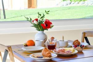 a table with breakfast food and a vase with flowers at Agriturismo De Ferrari in Onzo
