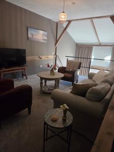 a living room with a couch and a tv at De Citadel - De Boomgaard in Markelo