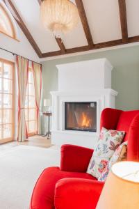 a living room with a red couch and a fireplace at Gästehaus Eltz - Your Austrian Home in Puchen