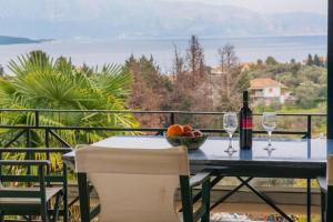 a table with a bottle of wine and glasses on a balcony at Nikiana Panorama in Nikiana