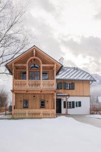 a large wooden house with a balcony at Gästehaus Eltz - Your Austrian Home in Puchen