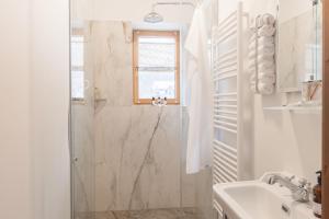 a white bathroom with a shower and a sink at Gästehaus Eltz - Your Austrian Home in Puchen +22 photos