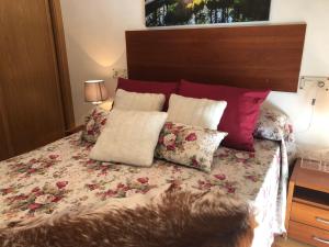 a bed with pillows on it in a bedroom at O Xuncal in San Cosme de Barreiros