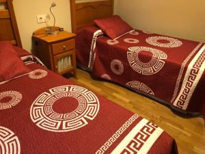 a bedroom with two beds and a night stand at O Xuncal in San Cosme de Barreiros +1 photo