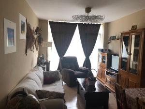 a living room with a couch and a tv at O Xuncal in San Cosme de Barreiros
