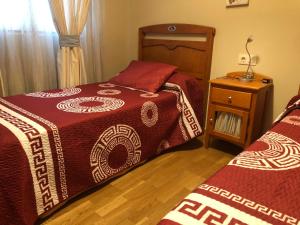 a bedroom with two beds and a night stand at O Xuncal in San Cosme de Barreiros