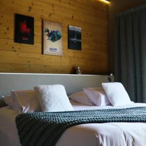 a bedroom with a bed with white sheets and pillows at World Hotel in Saint-Vulbas