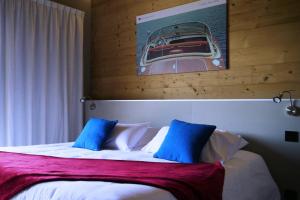 a bed with blue and white pillows in a room at World Hotel in Saint-Vulbas