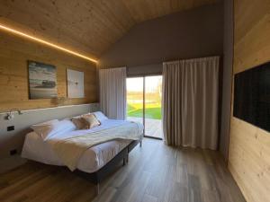 a bedroom with a bed and a large window at World Hotel in Saint-Vulbas