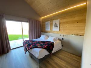 a bedroom with a bed and a large window at World Hotel in Saint-Vulbas