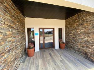 a brick wall with two potted plants and a door at World Hotel in Saint-Vulbas +15 photos