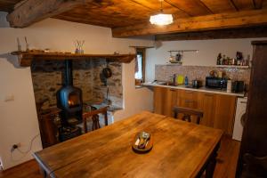 a kitchen with a wooden table and a wood stove at Walser House in Rimella